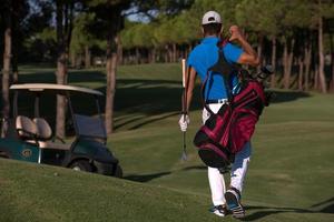 golfer  walking and carrying golf  bag photo