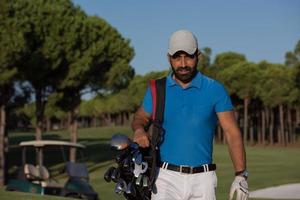 golfer  walking and carrying golf  bag photo