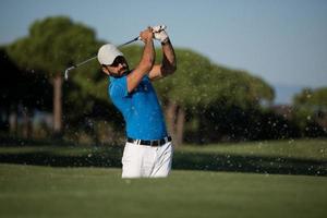 pro golfer hitting a sand bunker shot photo