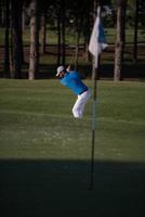 pro golfer hitting a sand bunker shot photo