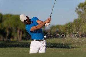 pro golfer hitting a sand bunker shot photo