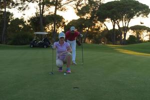 couple on golf course at sunset photo