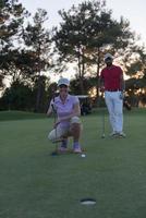 couple on golf course at sunset photo