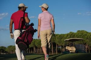 pareja caminando en campo de golf foto