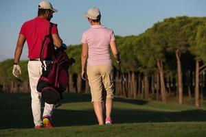 pareja caminando en campo de golf foto