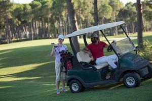 couple in buggy on golf course photo