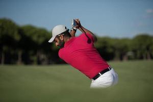 golfista golpeando un tiro de búnker de arena foto