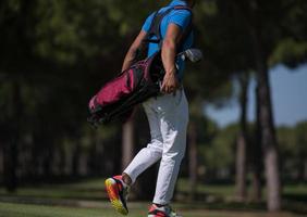 golf player walking and carrying bag photo