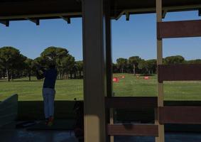 golf player practicing shot on training photo