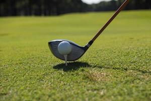 golf player placing ball on tee photo