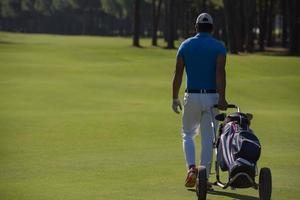 golf player walking with wheel bag photo