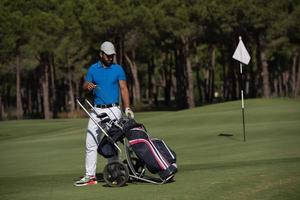 golf player walking with wheel bag photo