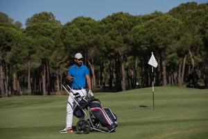 golf player walking with wheel bag photo