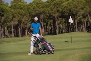 golf player walking with wheel bag photo