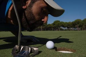 golf player blowing ball in hole photo