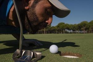 golf player blowing ball in hole photo