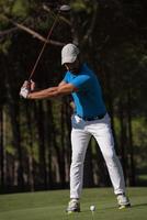 golf player hitting shot photo