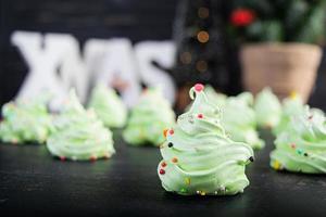 galletas de merengue con decoración navideña. postre francés. arbol de navidad de merengue foto