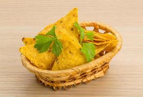 Nachos in a basket on wooden background photo