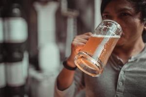 Asian man raising a glass of craft beer drinking photo