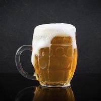 Mug of light beer on dark background. Craft unfiltered beer photo