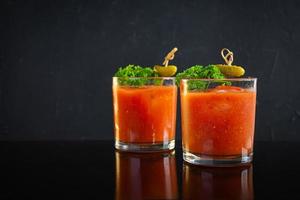 Alcohol cocktail Bloody Mary on dark background. Classic cocktail with tomato juice and vodka photo