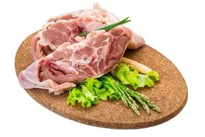 Raw lamb on wooden board and white background photo