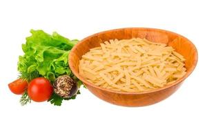 Raw pasta in a bowl on white background photo