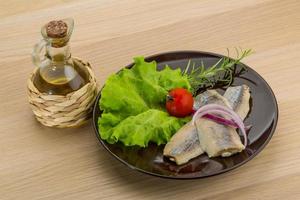 Herring fillet on the plate and wooden background photo