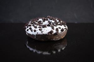 Single doughnut on dark background. Delicious doughnut with chocolate photo