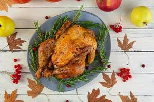 Baked whole chicken or turkey. Roasted homemade chicken with herbs. Thanksgiving day decoration. Top view photo