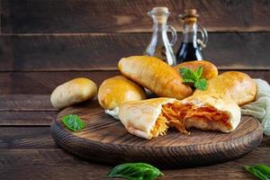 Traditional Russian cabbage pies on wooden background. Baked homemade pirozhki with cabbage photo