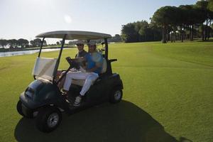 golf players driving cart at course photo