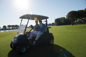 golf players driving cart at course photo