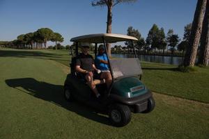 golf players driving cart at course photo