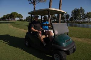 golf players driving cart at course photo