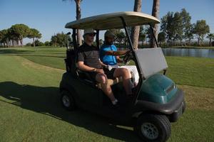 golf players driving cart at course photo