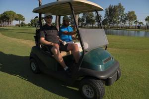 jugadores de golf conduciendo un carro en el campo foto