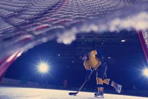 jugador adolescente de hockey sobre hielo en acción foto