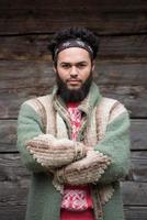 portrait of young hipster in front of wooden house photo