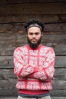 portrait of young hipster in front of wooden house photo