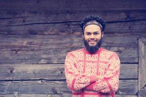 portrait of young hipster in front of wooden house photo