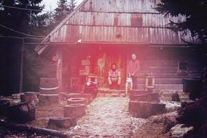 frineds together in front of old wooden house photo