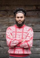 portrait of young hipster in front of wooden house photo