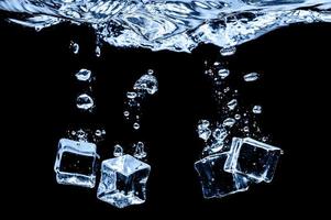 Ice cubes in water on studio dark background. The concept of freshness with coolness from ice cubes. photo