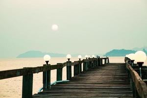 una pasarela de madera que se adentra en el mar. concepto de viaje de vacaciones foto