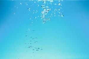 imagen de fondo abstracto de burbujas en el agua. agua limpia con gotas de agua y olas. agua dulce un vaso con burbujas de fondo azul. foto