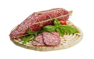 Salami on wooden plate and white background photo