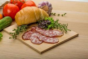 Salami on wooden plate photo