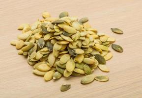 Pumpkin seeds on wooden background photo